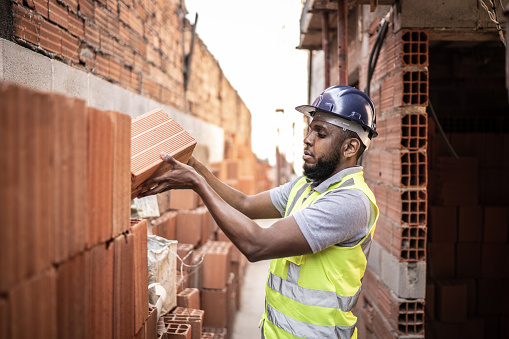 Construction worker building a brick wall