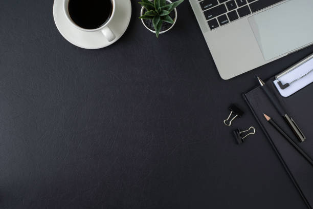 istock Black leather office desk table. Workspace with keyboard of laptop computer 1334832040