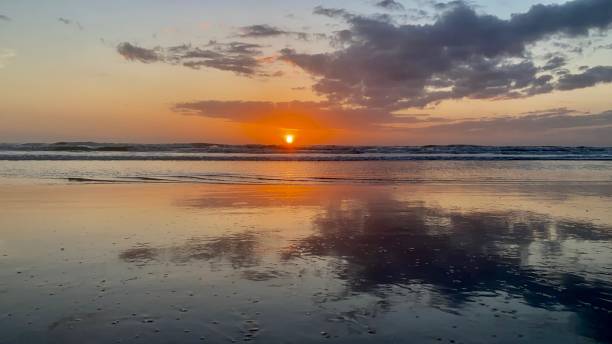 istock Sun sunrise reflection of dark clouds Florida 1334832045