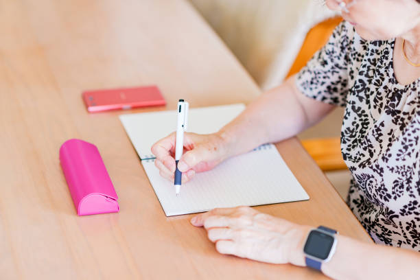 istock Japanese senior woman writing memo on notebook 1334832129