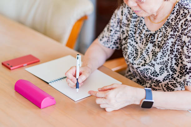 istock Japanese senior woman writing memo on notebook 1334832140