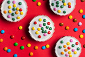 Cacao sweet muffins with white chocolate and colorful bonbons