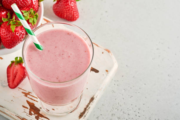 strawberry smoothie or milkshake with berries and mint in tall glass on light grey background. summer drink shake, milkshake and refreshment organic concept. place for text. - healthy eating food and drink nutrition label food imagens e fotografias de stock