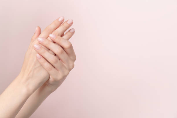 Stylish trendy nail young woman hands pink manicure on pink background stock photo