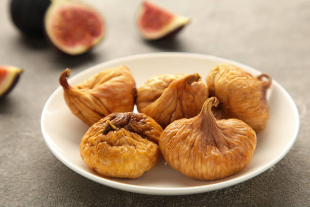 istock Group of dried figs in a bowl on grey background. 1334841565