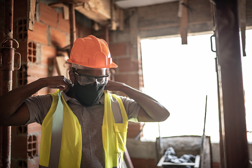 Construction worker dressing his uniform and protective workwear at a construction site