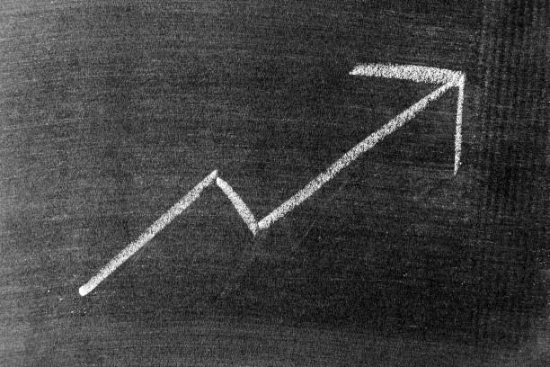 istock White chalk draw as upward arrow graph on blackboard or chalkboard background (Concept for sale, profit, cost of company in uptrend) 1334846806