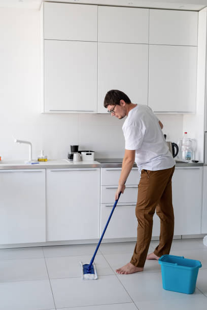 istock Man cleaning home with mop 1334847102