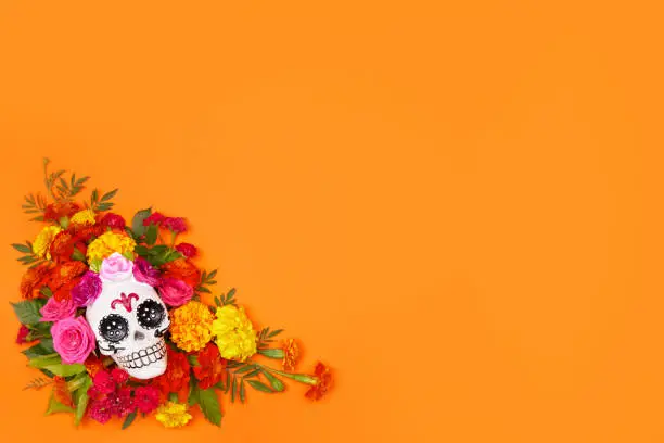 Day of the dead, Dia De Los Muertos, halloween Celebration Background. Sugar Skull, calaverita, marigolds flowers, Orange Copy Space. Traditional Mexican culture festival flyer. Flat lay, top view.