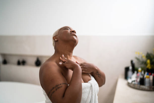 mujer que se aplica la mayorura corporal en el baño de casa - touching neck fotografías e imágenes de stock