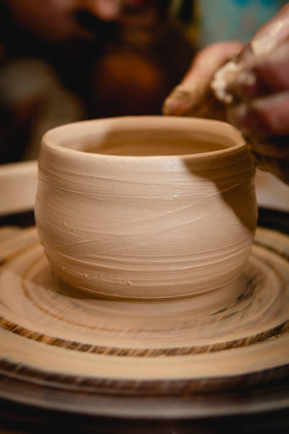 istock Potter working on potters wheel with clay. 1334851394
