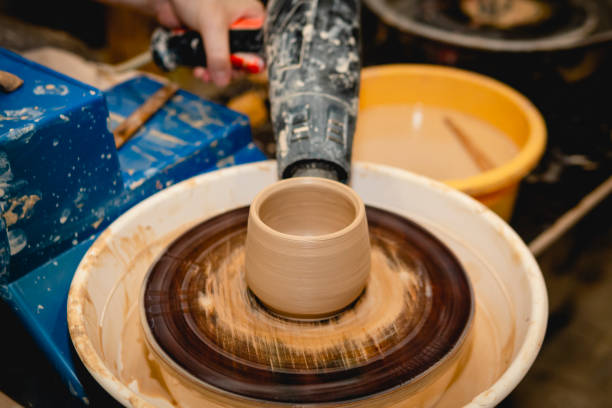 istock Potter working on potters wheel with clay. 1334851449