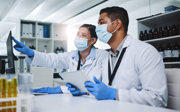 istock Shot of two young researchers using digital devices in a laboratory 1334851573