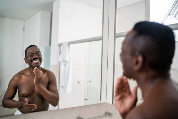 istock Senior man applying moisture on face at home 1334852106