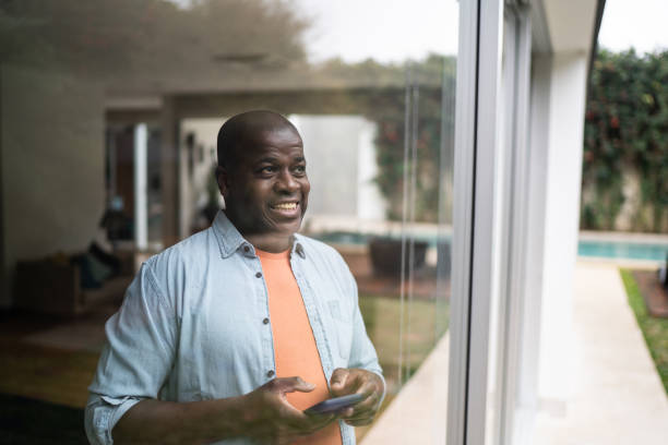 istock Men contemplating holding a smartphone at home 1334854848