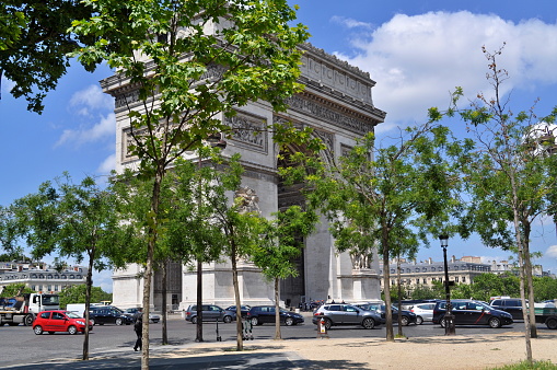 Paris, France - June 14, 2019. Arc de Triomphe de I'Étoile - one of the symbols of Paris during nice summer day.