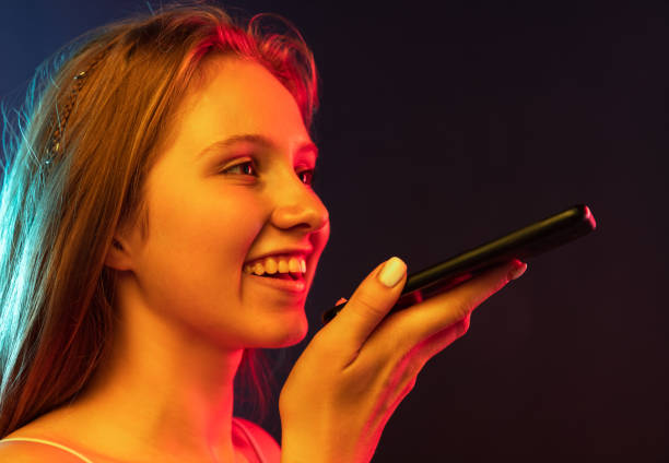 istock Close-up young beautiful girl using phone isolated on dark blue studio background. Concept of human emotions, facial expression, youth, sales, ad , gadgets 1334856478