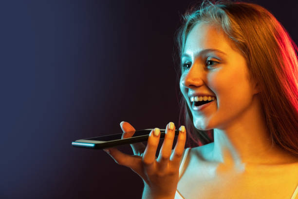 istock Close-up young beautiful girl using phone isolated on dark blue studio background. Concept of human emotions, facial expression, youth, sales, ad , gadgets 1334856480