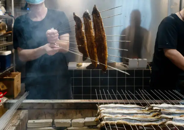 The cook is roasting eels