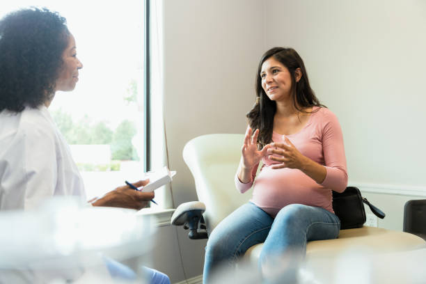 istock Pregnant woman gestures while sharing with female obstetrician 1334856806