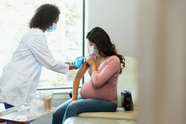 schwangere frau erhält impfung in arztpraxis - human pregnancy midwife visit healthcare and medicine stock-fotos und bilder