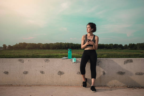 istock Asian woman resting use mobile phone after exercise. 1334858830