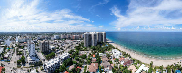 An aerial view of the Atlantic Ocean and West Palm Beach, Florida Beautiful white sand beaches and turquoise waters sparkle in the sunshine. The sky is filled with puffy white clouds