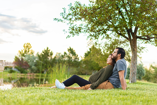 In Western Colorado Young Couple of Colombian Ethnicity Sitting Together on Grass Beside a Pond Photo Series Matching 4K Video Available (Shot with Canon 5DS 50.6mp photos professionally retouched - Lightroom / Photoshop - original size 5792 x 8688 downsampled as needed for clarity and select focus used for dramatic effect)