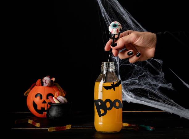 istock Scary colorful Halloween cocktail with party decorations on dark background with copy space 1334864572