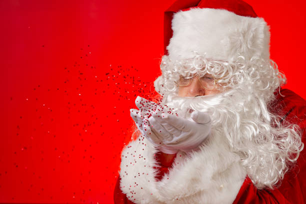 istock santa claus blowing red glitter confetti from hands 1334864923