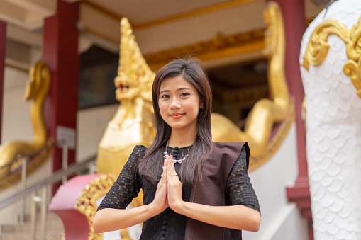 Portrait of a young beautiful Burmese girl standing in front of a Burmese temple.