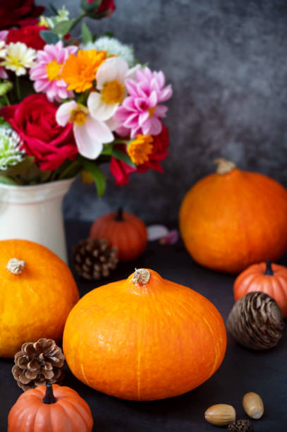 istock Pumpkins. Autumn creative flatlay, dark background with candles, autumn flowers, pine cones and pumpkins. 1334866310