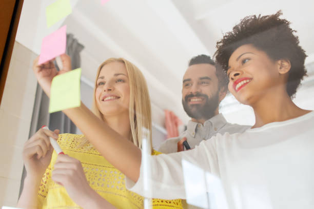 istock happy creative team writing on stickers at office 1334867099