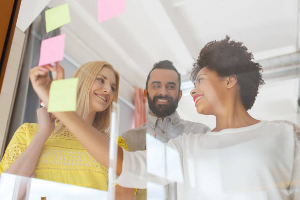 istock happy creative team writing on stickers at office 1334867774
