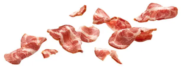 Photo of Sliced bacon isolated on white background, falling ham strips