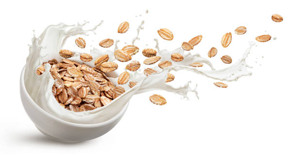 istock Oat flakes with milk splashes isolated on white background 1334868183