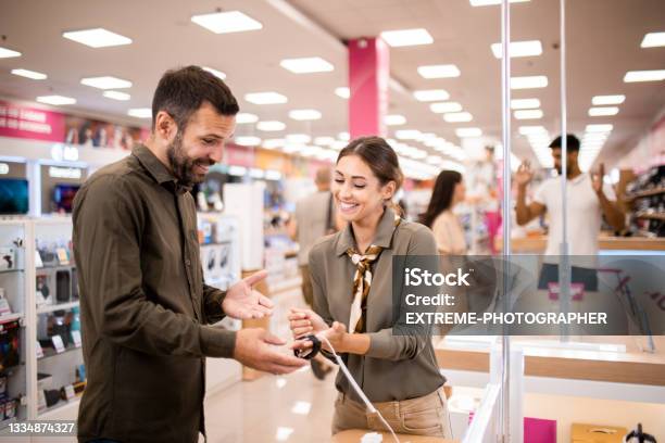 Male Customer Receiving Assistance From A Saleswoman Stock Photo - Download Image Now