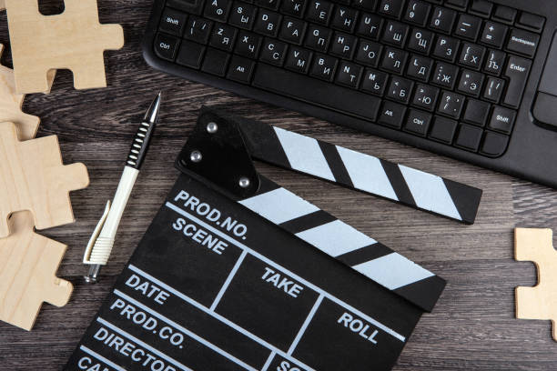 istock cinematic  clapper, pc keyboard, pen and puzzle pieces on a table top view 1334878294
