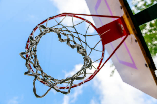 istock basketball hoop against blue sky and green trees 1334883838