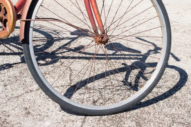 Detail of old rusty bicycle and its shadow on the floor, in Zadar, Croatia