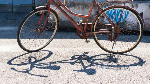 Old rusty bicycle and its shadow on the floor, in Zadar, Croatia