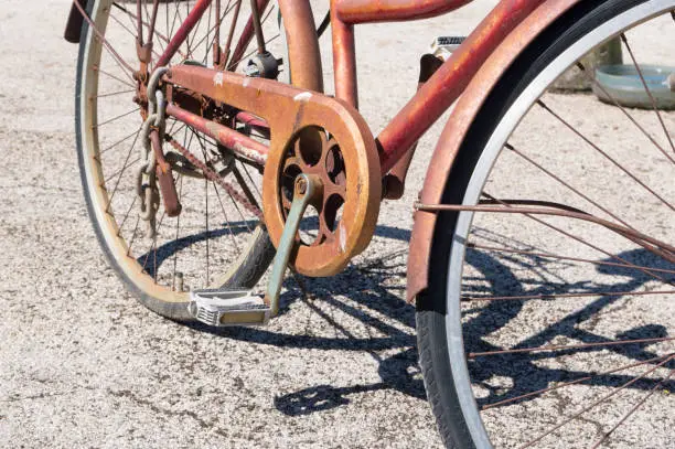 Detail of old rusty bicycle with pedal and chain and its shadow on the floor, in Zadar, Croatia