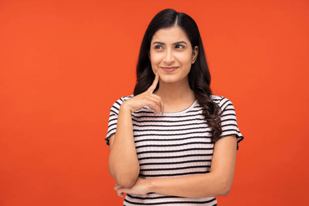 young woman on orange background, - aspirations choice choosing women imagens e fotografias de stock