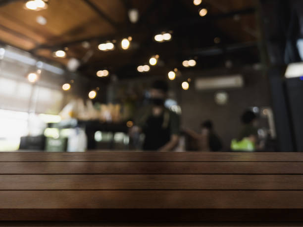 istock Empty wooden table top with lights bokeh on blur restaurant background 1334887819