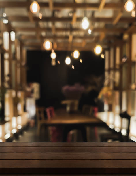 Empty wooden table top with lights bokeh on blur restaurant background