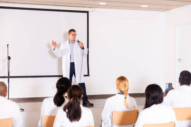 istock Speaker in white coat giving presentation at medical conference 1334888059
