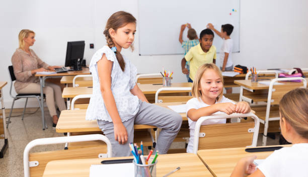 istock Cheerful preteen classmates talking at recess between lessons 1334889861