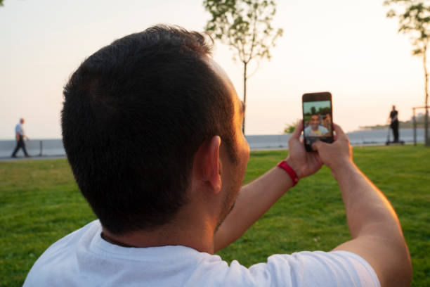 istock Young man sitting on grass and using smart phone. 1334890622