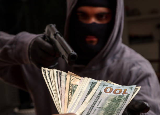 Criminal with gun and stack of money