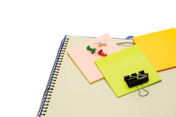 istock Colorful sticky note with paper clips above a notebook on white background 1334891445